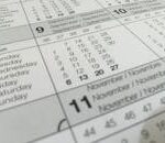 Detailed close-up of a calendar displaying months in several languages.